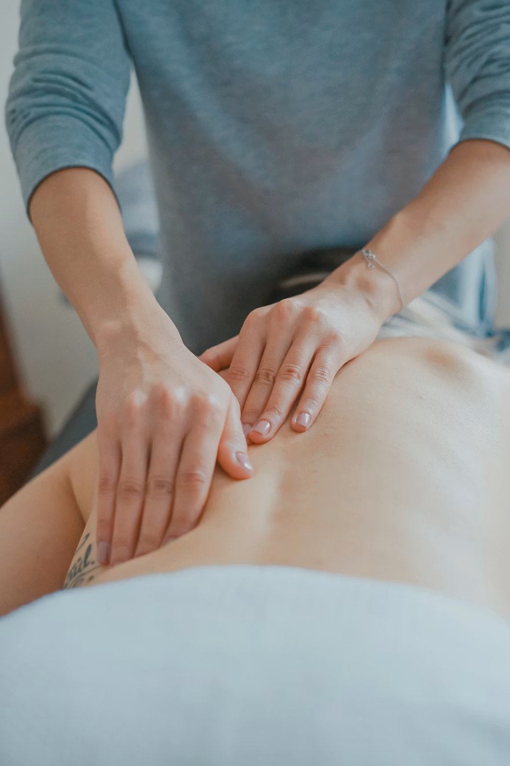 Therapist’s hands resting on a guest’s shoulders