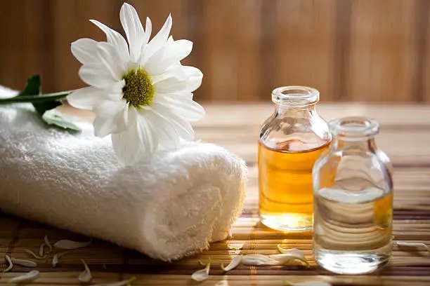 Aromatherapy massage with essential oil bottles and steam diffuser